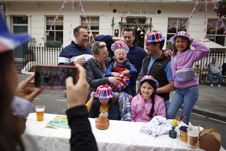 People pose for a photo during a public street party in central London, Sunday June 5, 2022, on the last of four days of celebrations to mark the Platinum Jubilee. Street parties are set to be held across the country in what is being called The Big Jubilee Lunch. The events over a long holiday weekend in the U.K. have celebrated Queen Elizabeth II's 70 years of service. (AP Photo/David Cliff)