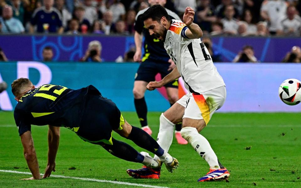 Ryan Porteous (L) fouls Germany's midfielder #21 Ilkay Gundogan