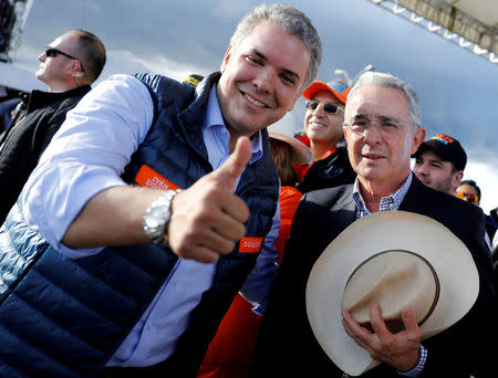 FILE PHOTO: Colombian former president Alvaro Uribe (R) and right-wing presidential candidate Ivan Duque pose during a closing campaign rally in Bogota, Colombia May 20, 2018. REUTERS/Nacho Doce/File Photo