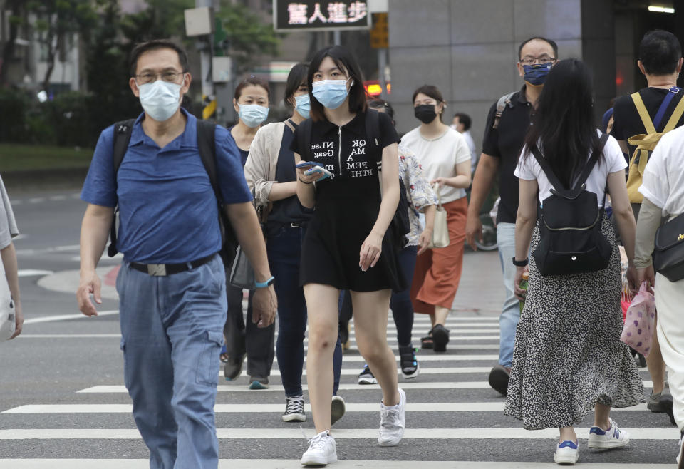 People wear face masks to help protect against the spread of the coronavirus in Taipei, Taiwan, Thursday, April 28, 2022. Taiwan, which had been living mostly free of COVID-19, is now facing its worst outbreak since the beginning of the pandemic with over 11,000 new cases reported Thursday.(AP Photo/Chiang Ying-ying)