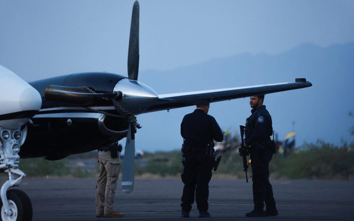 Agents stand by a plane believed to have carried Mr Zambada Garcia and Mr Guzman Lopez