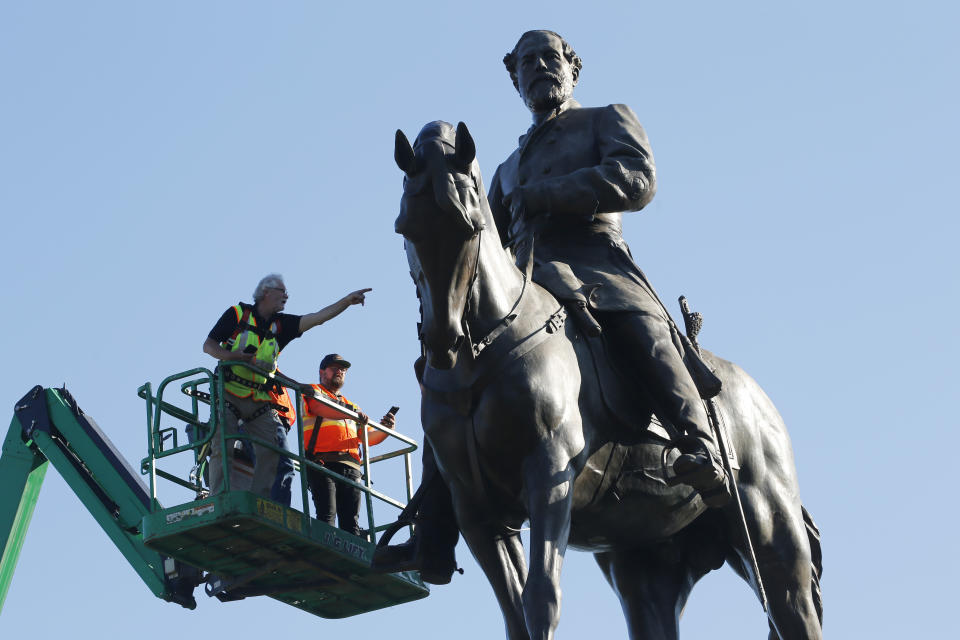 FILE - In this Monday June 8, 2020 file photo a crew from the Virginia Department of General Services inspect the statue of Confederate Gen. Robert E. Lee on Monument Avenue in Richmond, Va. If a court clears the way for the state of Virginia to take down one of the country's most prominent Confederate statues, contractors will also be removing something else from the enormous monument: a 134-year-old time capsule rumored to contain a valuable and historically significant photo of deceased President Abraham Lincoln. (AP Photo/Steve Helber)