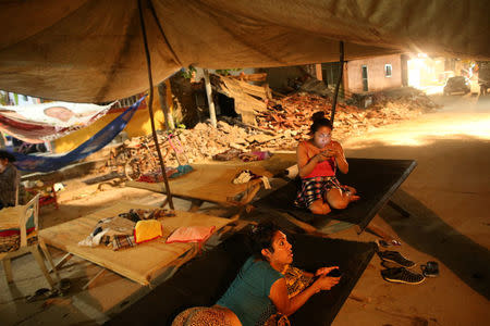 Ximena, 26 and Peregrina, 26, indigenous Zapotec transgender women also knows as Muxe, rest on a street after an earthquake that struck on the southern coast of Mexico late on Thursday, in Juchitan, Mexico, September 10, 2017. REUTERS/Edgard Garrido