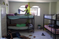 Endy Doblasse, una mujer transexual de 23 años, limpia su cama antes de dormir una siesta en la habitación que comparte con otros tres residentes en el centro Kay Trans Haití, en Puerto Príncipe, Haití, el 16 de agosto de 2020. Según los residentes, el vecindario donde se ubica el centro los acepta cada vez más, creando una isla segura en una ciudad donde normalmente se sienten vulnerables y objeto de abusos en cualquier momento. (AP Foto/Dieu Nalio Chery)