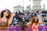 Dancers wearing swim suits dance in front of spectators under umbrella's during the Women's beach volleyball preliminary phase pool E Australia v Germany at Horse Guards Parade for the Olympic Games in London, Sunday, July 29, 2012. (AAP Image/Tracey Nearmy) NO ARCHIVING