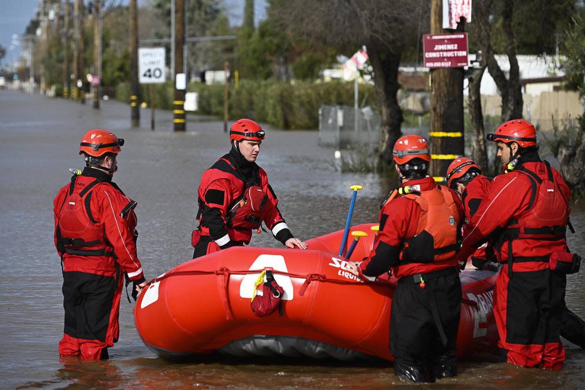 Members of the Bakersfield Fire Department are shown deploying a raft on a flooded-out section of Highway 59 on Tuesday, Jan. 10, 2023 in Merced, CA.