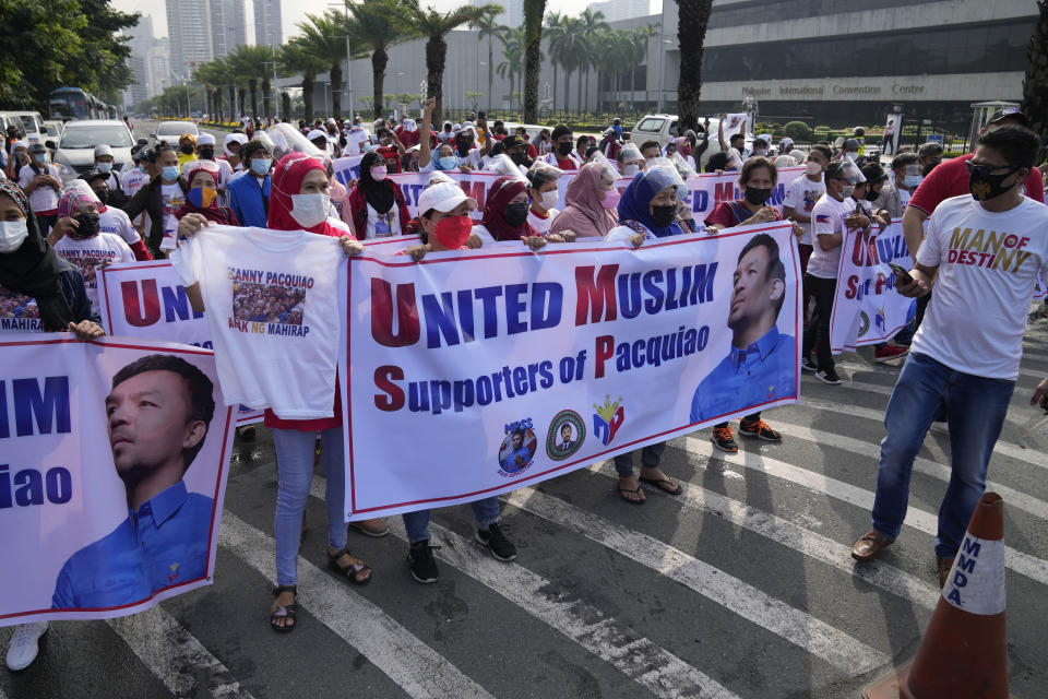 Supporters of retired Filipino boxing star and senator Manny Pacquiao gather near an area where he will file his certificate of candidacy for next year's presidential elections before the Commission on Elections on Friday, Oct. 1, 2021, in Manila, Philippines. Friday marks the start of a weeklong registration period for candidates seeking to lead a Southeast Asian nation that has been hit hard by the pandemic and deep political conflicts.(AP Photo/Aaron Favila)