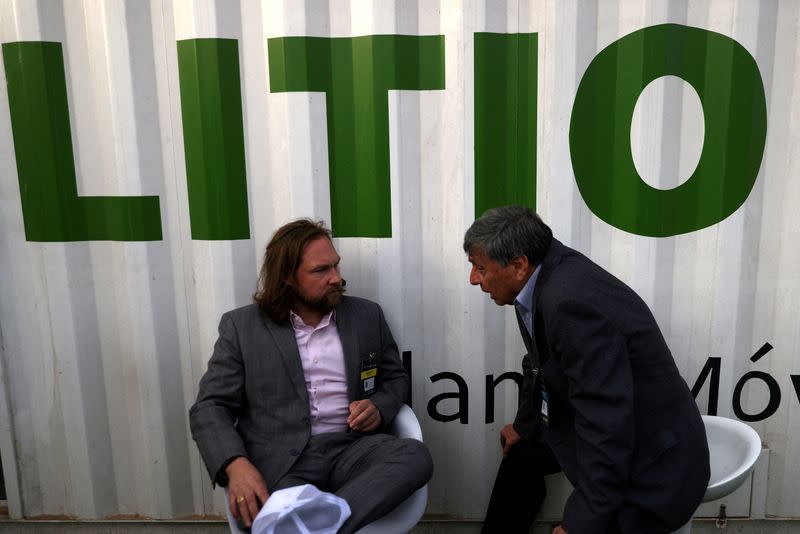 FILE PHOTO: Exhibitors chat next to a signboard reading "Lithium" during a mining fair in Santiago