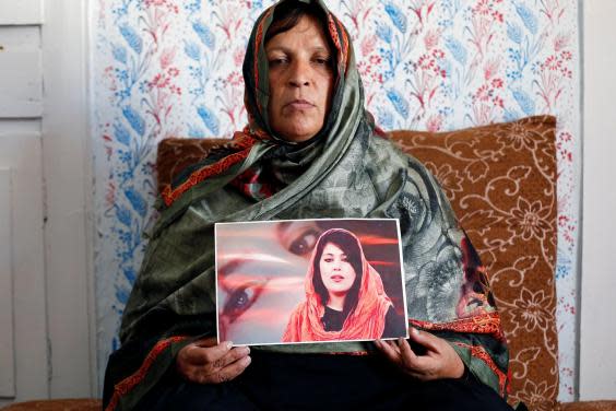 Anisa Mangal holds a photo of her daughter (Reuters)