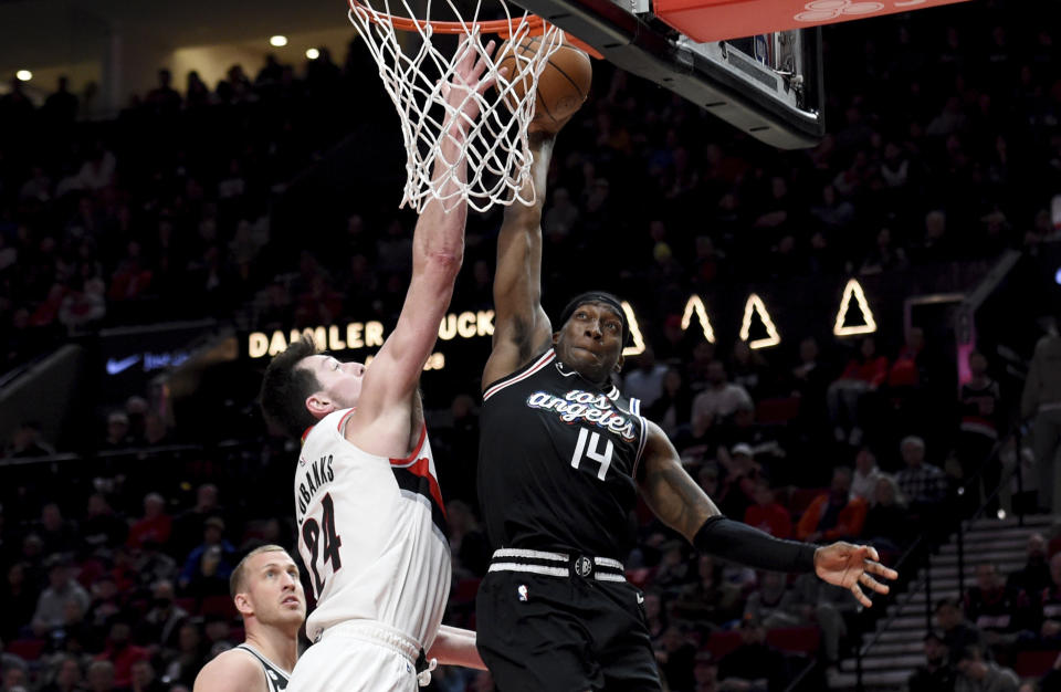 Portland Trail Blazers forward Drew Eubanks, left, blocks the shot of Los Angeles Clippers guard Terance Mann, right, during the second half of an NBA basketball game in Portland, Ore., Sunday, March 19, 2023. The Clippers won 117-102. (AP Photo/Steve Dykes)