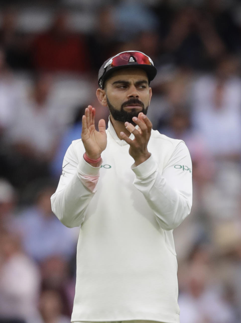 India's captain Virat Kohli applauds England's Chris Woakes on 120 not out, as they leave the pitch after bad light stopped play, during the third day of the second test match between England and India at Lord's cricket ground in London, Saturday, Aug. 11, 2018. (AP Photo/Kirsty Wigglesworth)