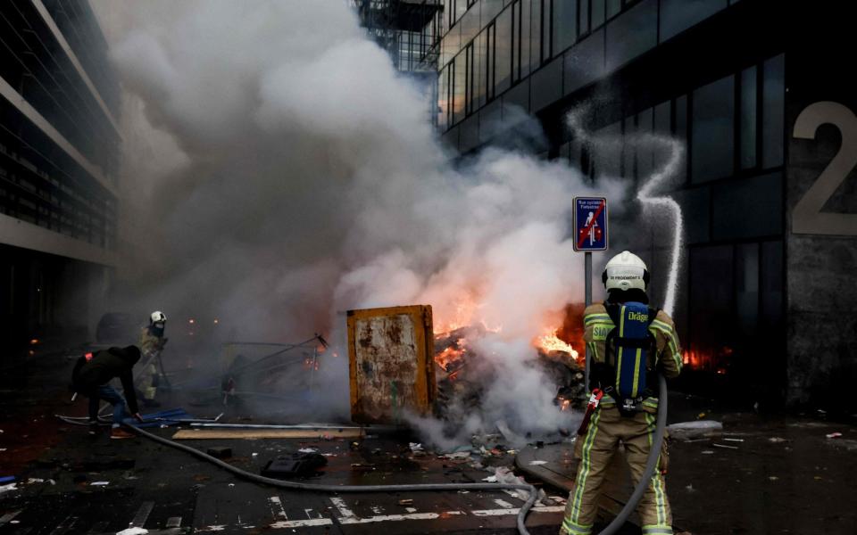 Belgian firefighters work to put out a fire during a demonstration  - KENZO TRIBOUILLARD/AFP