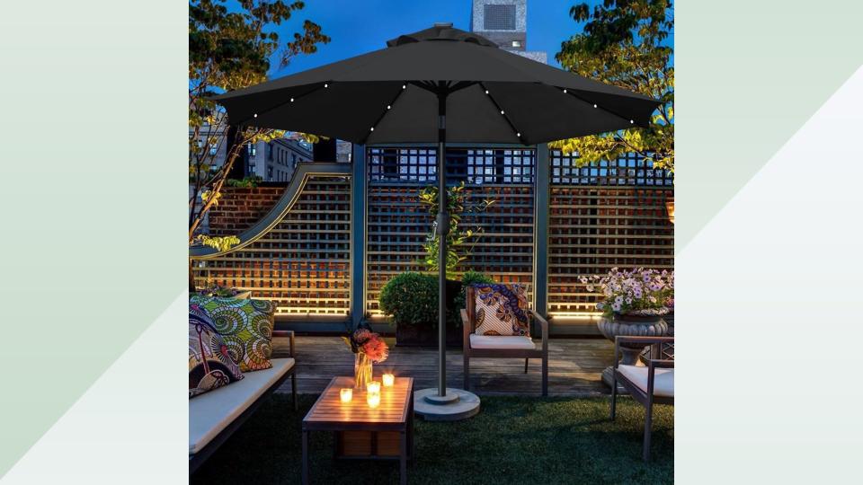 Patio at night with illuminated umbrella. 