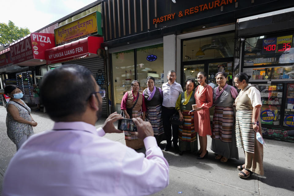 Alexandria Ocasio-Cortez (tercera desde la der) posa para una foto con varios inmigrantes de Nepal durante una visita al barrio neoyorquino de Jackson Heights el 6 de julio del 2022. (AP Photo/Mary Altaffer)