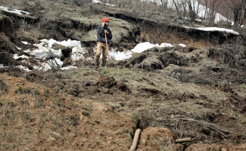 A man stands on a hillside after a mudslide near Mountain Green in Morgan County on Monday, April 17, 2023. | Kristin Murphy, Deseret News