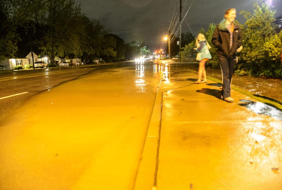 Bystanders look at the flooding as creek and sewer waters spill into the road, causing traffic issues, Monday, April 28, 2014, on Hargrove Road East near the Woodlands of Tuscaloosa apartment complex in Tuscaloosa, Ala. (AP Photo/Alabama Media Group, Vasha Hunt)