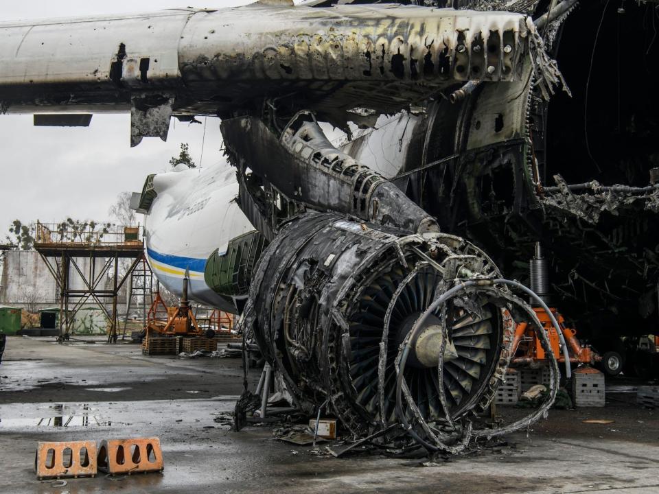 Part of the fuselage, with a large hole, as well as the right wing and a ruined engine, are in view.