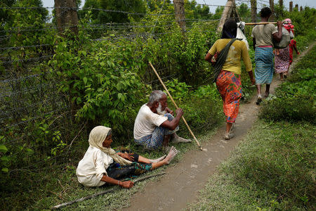 Elderly Rohingya man and woman take a rest along a barbed wire fence as they wait for boat to cross the border through Naf river in Maungdaw, Myanmar, September 7, 2017.REUTERS/Mohammad Ponir Hossain