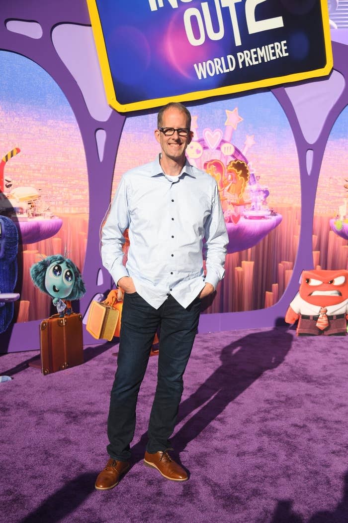 Pete Docter stands on a purple carpet at the 'Inside Out 2' world premiere, surrounded by characters from the movie