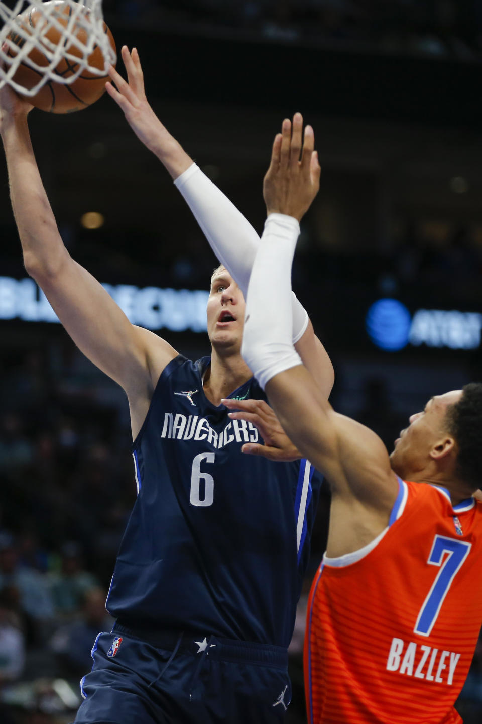 Dallas Mavericks forward Kristaps Porzingis (6) attempts a layup as Oklahoma City Thunder forward Darius Bazley (7) defends during the first half of an NBA basketball game, Monday, Jan. 17, 2022, in Dallas. (AP Photo/Brandon Wade)