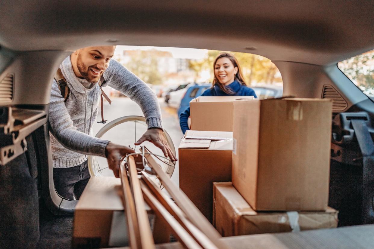 Young couple moving in new apartment with pick-up truck