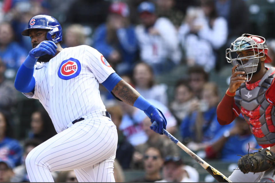 Chicago Cubs' Franmil Reyes left, watches his RBI single while Cincinnati Reds catcher Chuckie Robinson, right, looks on during the first inning of a baseball game, Sunday, Oct. 2, 2022, in Chicago. (AP Photo/Paul Beaty)