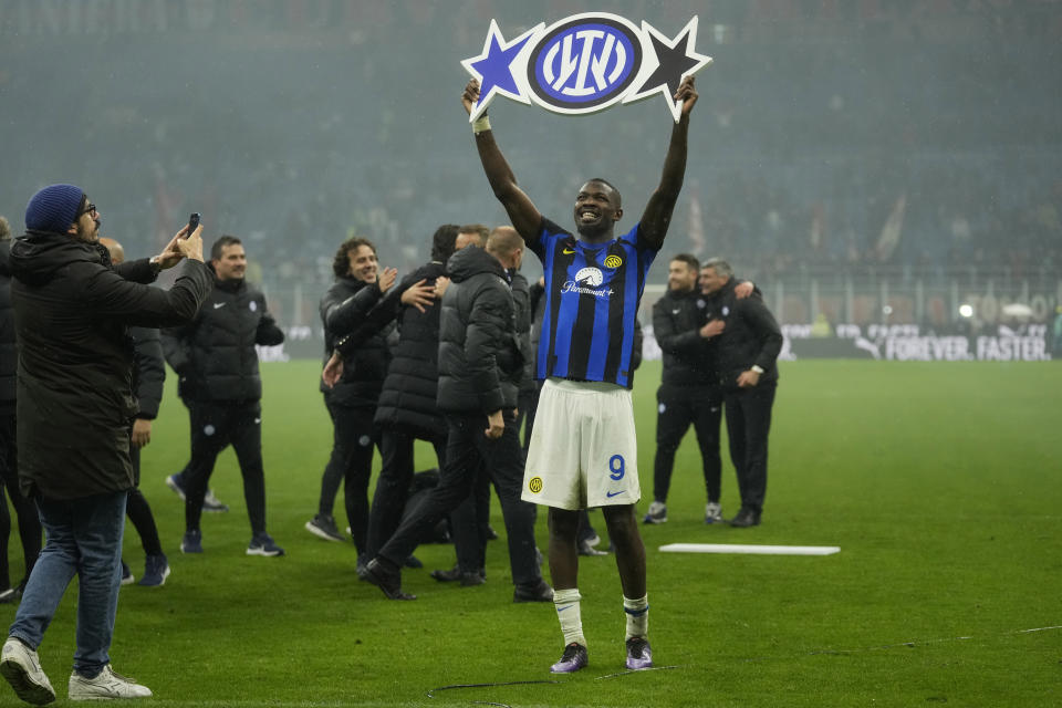 Marcus Thuram del Inter de Milán celebra el título de la Serie A levantando una imagen del escudo con la segunda estrella al final del encuentr ante el AC Milan en San Siro el lunes 22 de abril del 2024. (AP Foto/Luca Bruno)