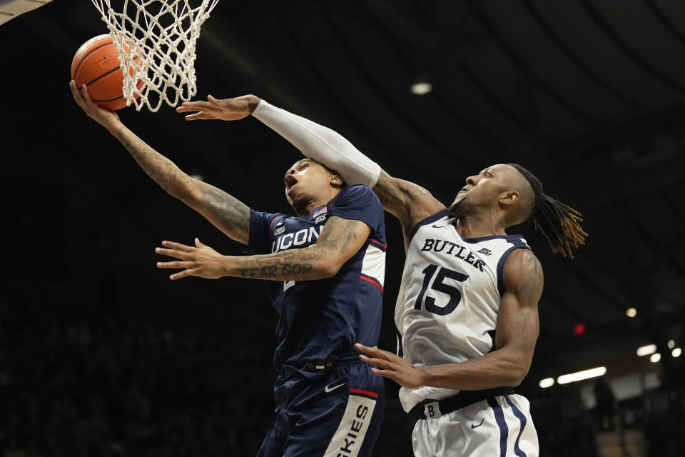 Connecticut guard Jordan Hawkins, left, is fouled while shooting by Butler center Manny Bates in the second half of an NCAA college basketball game in Indianapolis, Saturday, Dec. 17, 2022. (AP Photo/AJ Mast)