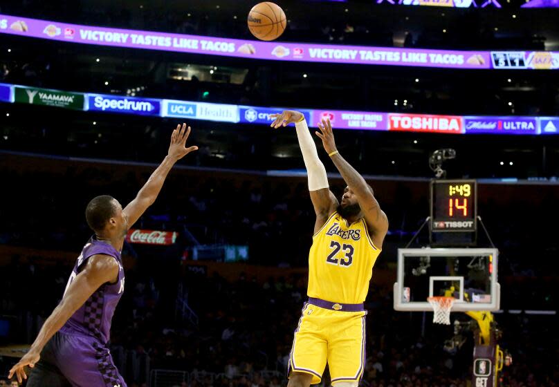 Los Angeles, CA - Lakers forward LeBron James shoots and scores a three-pointer against Kings defender Harrison Barnes in the first half at crypto.com Arena in Los Angeles on Wednesday night, Nov. 15, 2023. (Luis Sinco / Los Angeles Times)