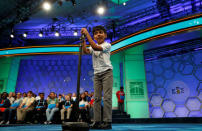 Akash Vukoti, 6, of San Angelo, TX, the youngest contestant at the 89th annual Scripps National Spelling Bee, lowers the microphone for his turn during a preliminary round at National Harbor in Maryland, U.S., May 25, 2016. REUTERS/Kevin Lamarque