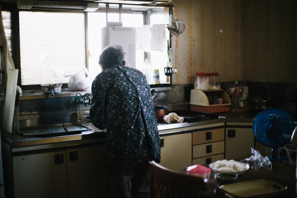 Grandmother is preparing breakfast at her kitchen.