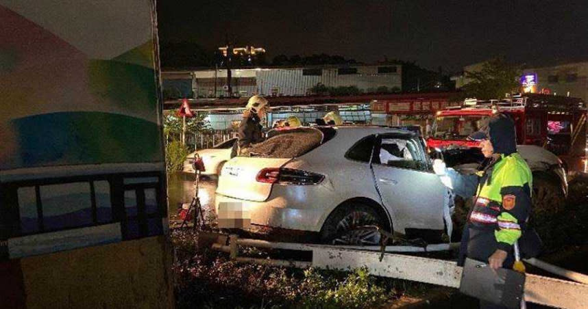 保時捷自撞分隔島，駕駛受困在內，警消到場後將他救出送醫。（圖／翻攝畫面）