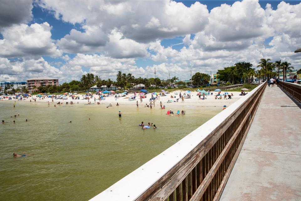 People visit the Fort Myers Beach pier on Thursday, August 12, 2021.