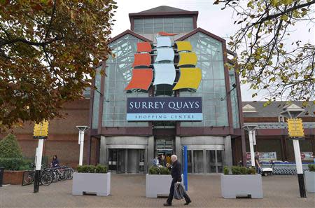 Pedestrians walk past the main entrance to the Surrey Quays shopping centre in south London, September 13, 2013. REUTERS/Toby Melville
