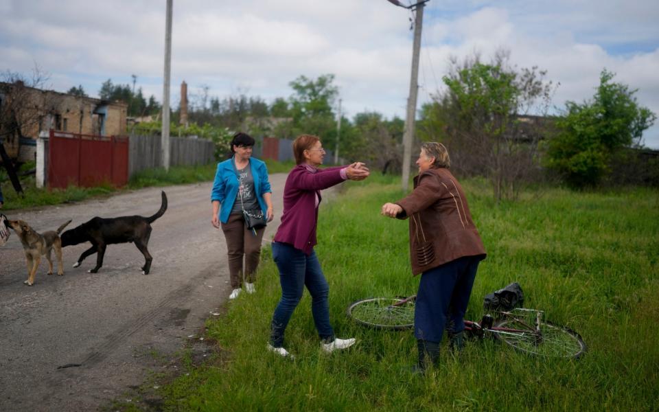 Nila Zelinska, center, is about to embrace her neighbor as she arrives to her home that was destroyed during attacks, in Potashnya, on the outskirts of Kyiv, Ukraine, Tuesday, May 31, 2022. - AP Photo/Natacha Pisarenko