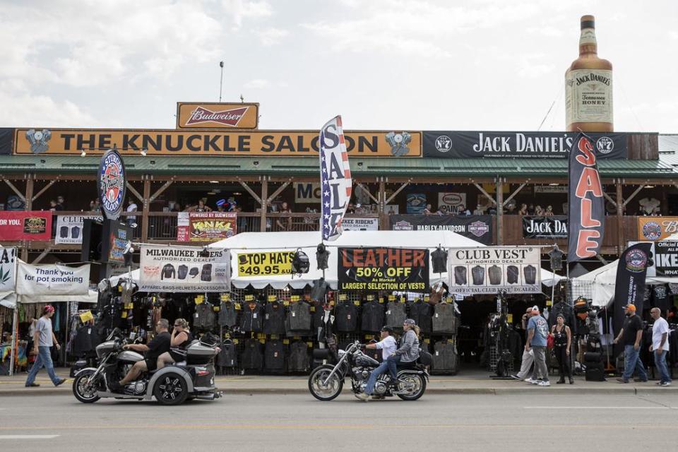 Riders drive past The Knuckle Saloon in downtown Sturgis during the 78th annual Sturgis Motorcycle Rally. A longtime rallygoer and his business partners are the new owners of The Knuckle Saloon and The Knuckle Brewing Company.