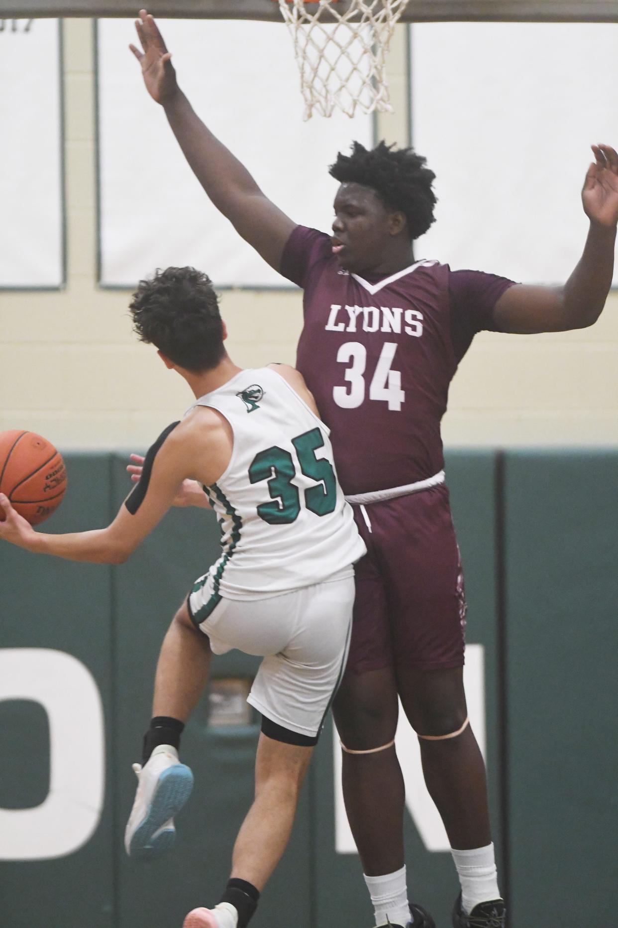 Jamire Johnson of Lyons defends as Jon Suro of Pembroke drives to the basket in the first quarter.