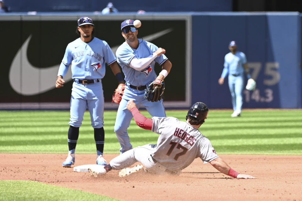 Toronto Blue Jays second baseman Whitt Merrifield, top right, throws to first base but not in time to complete a double play against Cleveland Guardians' Myles Straw after forcing out Austin Hedges (17) at second base in second-inning baseball game action in Toronto, Sunday, Aug. 14, 2022. (Jon Blacker/The Canadian Press via AP)