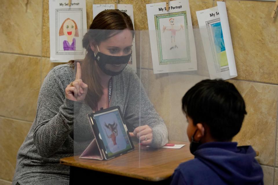 A teacher works with a student behind a shield at Freedom Preparatory Academy on September 10, 2020 in Provo, Utah. - In person schooling with masks has started up in many Utah schools since shutting down in March of this year due to the covid-19 virus. (Photo by GEORGE FREY / AFP) (Photo by GEORGE FREY/AFP via Getty Images)