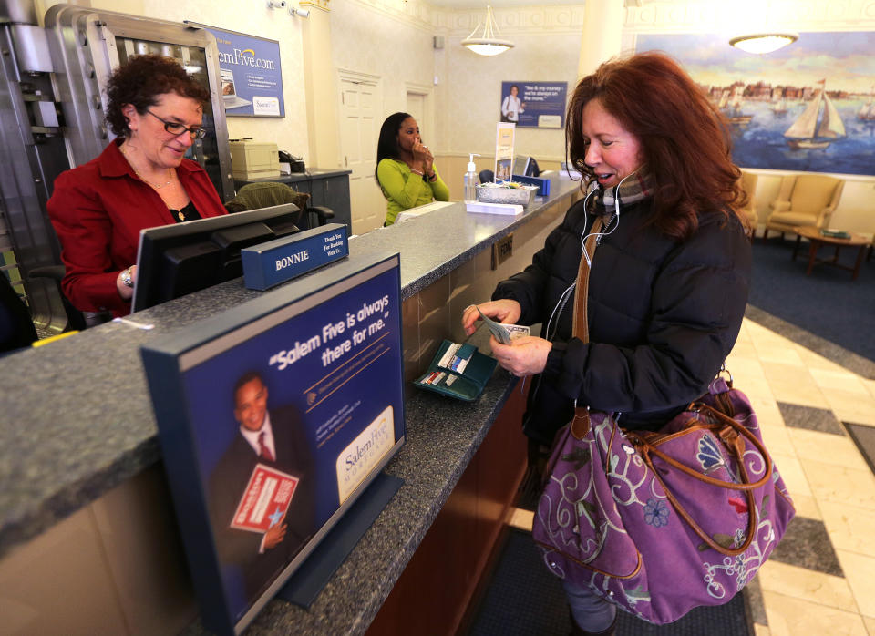 At right, Maura McCormick of Salem with Salem Five Bank Teller Bonnie Rubin, at far left. (Credit: Barry Chin/The Boston Globe via Getty Images)