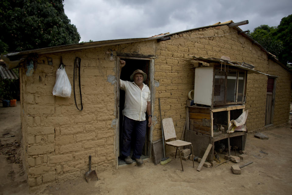 El agricultor Joao Batista Nascimento posa en su casa, construida con tierra sacada de los montículos elaborados por termitas, en Palmeiras, Brasil, el 25 de noviembre de 2018. Para los terratenientes que limpian los arbustos para plantar cultivos, su presencia es una molestia. Derribarlos es complicado porque, tras años al sol, la tierra y la arcilla están duras como piedras. (AP Foto/Victor R. Caivano)