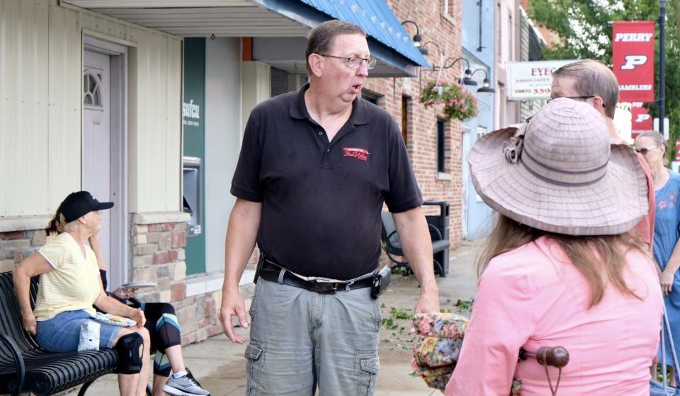 Jeff Kodet, owner of the True Value Hardware Store in downtown Perry, speaks to residents Saturday, Aug. 12, 2023, while offering anyone who needs a free lunch to get a burger or hot dog and water from a station he set up on the sidewalk. Friday an EF-1 tornado touched down and caused considerable damage to homes and businesses.