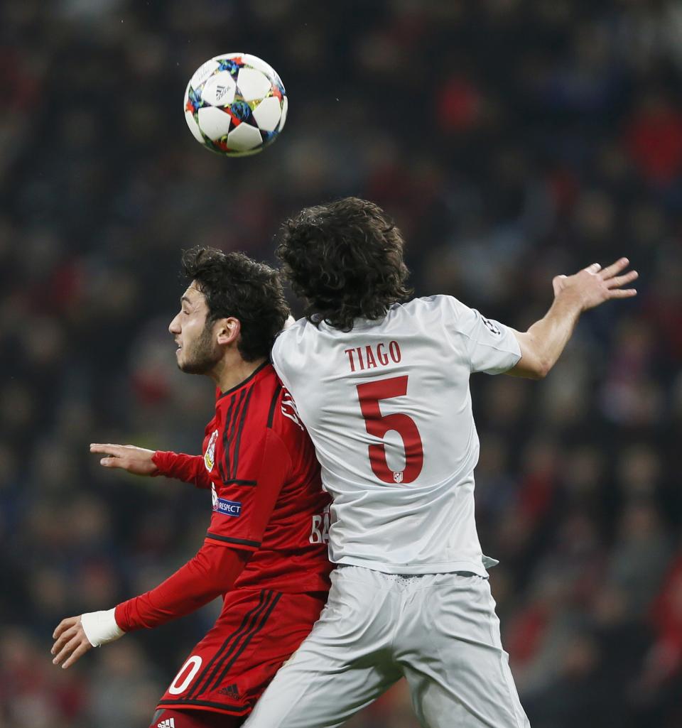 Bayer Leverkusen's Calhanoglu challenges Atletico Madrid's Mendes during Champions League soccer match in Leverkusen