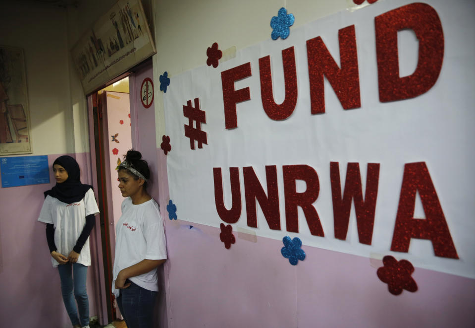 FILE - In this Sept. 3, 2018 file photo, Palestinian refugee students stand outside a classroom as they wait to attend a ceremony to mark the return to school of a new year at one of the UNRWA schools, in Beirut, Lebanon. The head of the U.N. agency that helps 5.3 million Palestinian refugees says it is mobilizing to replenish a $211 million shortfall in the face of U.S. funding cuts. Pierre Kraehenbuehl said Monday, June 17, 2019, in Jordan that UNRWA will start running out of money if it does not receive significant commitments at its pledging conference next week. (AP Photo/Hussein Malla, File)