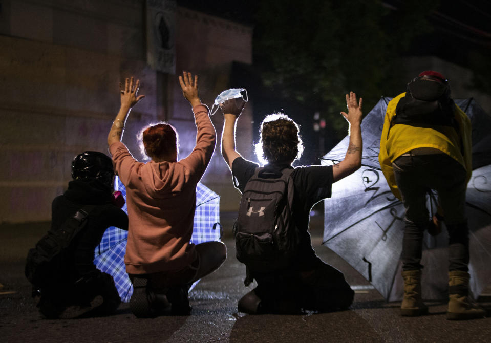 A march on the Portland police union headquarters drew a rapid police response after someone set a fire next to the building. Monday, Aug. 24, 2020. (Beth Nakamura/The Oregonian via AP)