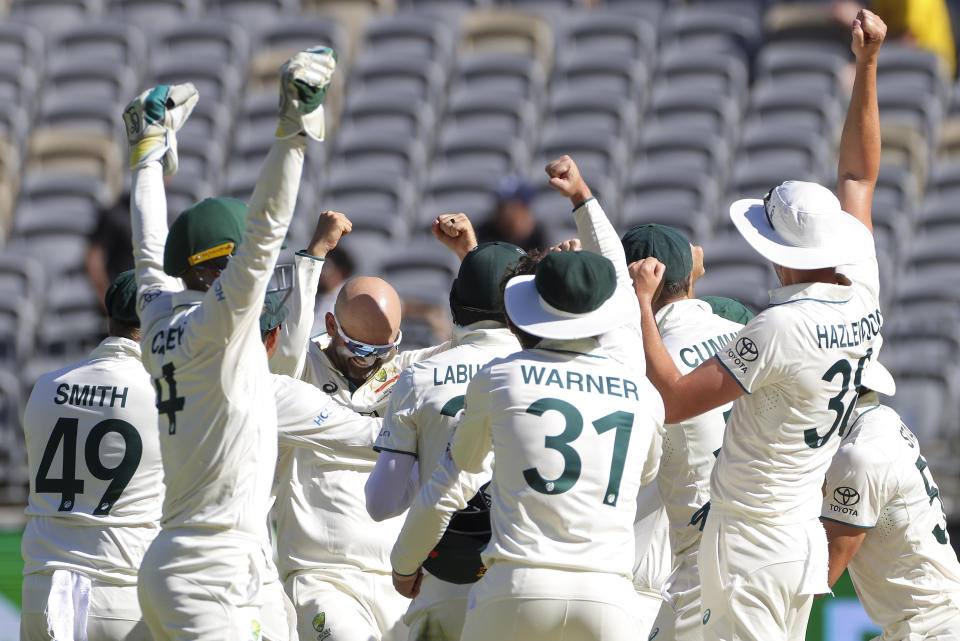 Australia's Nathan Lyon, centre, is congratulated by teammates after dismissing Pakistan's Faheem Ashraf to claim his 500th test match wicket during play on the fourth day of the first cricket test between Australia and Pakistan in Perth, Australia, Sunday, Dec. 17, 2023. Australia defeated Pakistan by 360 runs. (Richard Wainwright/AAP Image via AP)