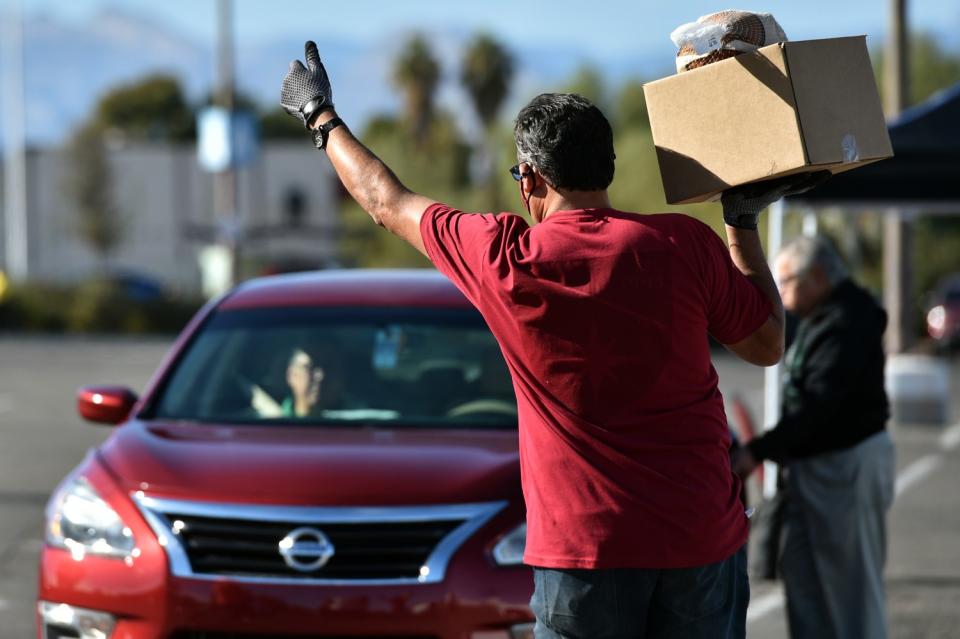 Greg Arce carries a Thanksgiving dinner for distribution during the Fall Giving Pop-Up.