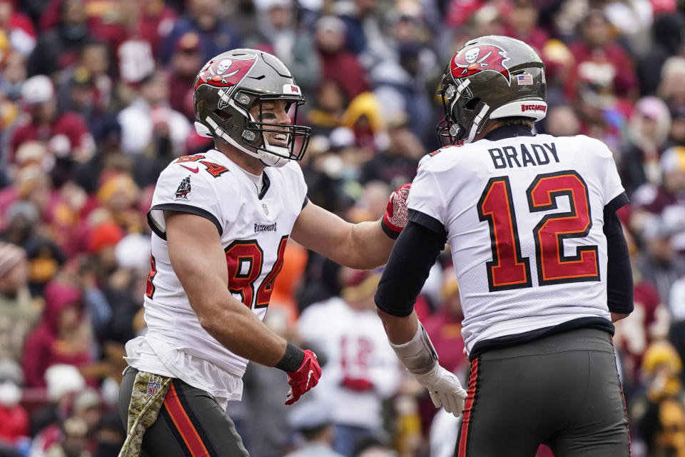 Tampa Bay Buccaneers tight end Cameron Brate (84) and quarterback Tom Brady (12) celebrate after connecting for a touchdown during the second half of an NFL football game against the Washington Football Team, Sunday, Nov. 14, 2021, in Landover, Md. (AP Photo/Patrick Semansky)