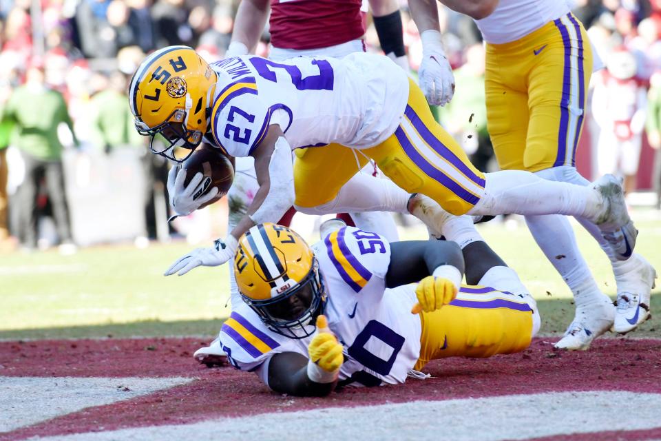 LSU running back Josh Williams leaps over teammate Emery Jones Jr. as he scores a touchdown against Arkansas.