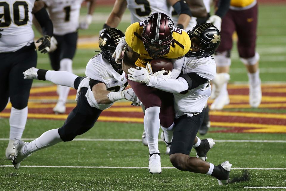 FILE - Minnesota wide receiver Chris Autman-Bell is tackled by Purdue safety Brennan Thieneman, left, and linebacker Jaylan Alexander during the first half of an NCAA college football game in Minneapolis, Friday, Nov. 20, 2020. Quarterback Tanner Morgan, running back Mo Ibrahim, wide receiver Chris Autman-Bell and center John Michael Schmitz will be major drivers of whatever success the Gophers enjoy in 2022. (AP Photo/Stacy Bengs, File)